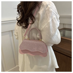 Detailed back view of model wearing a pink rhinestone crossbody bag with wavy edges