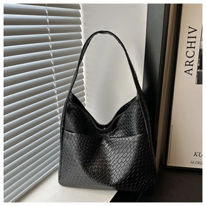 Close-up of a black woven leather Hobo bag featuring a minimalist crescent moon design