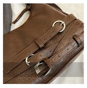 Detail of vintage brown faux leather texture with silver buckles and cross strap design