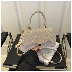 Detailed view of beige handbag with sparkling rhinestones and wavy scalloped flap