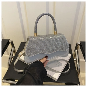Detailed view of silver glitter handbag with wave bottom and shiny rhinestone texture