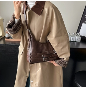 Détail du sac demi-lune vintage marron foncé avec boucles argentées et bandoulière