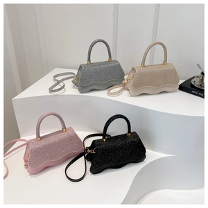 Detail of glittery mini flap bags in silver, gold, and pink with wave trim and gold hardware