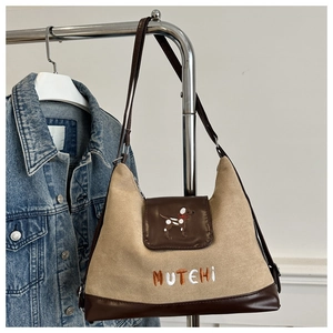 Detail view of retro tote bag featuring dog embroidery and premium brown leather trim