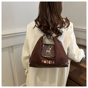 Detail of brown suede tote bag with cartoon hound embroidery and MUTEHI text