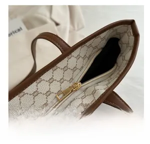 Close-up of smooth gold metal zipper closure on a vintage plaid canvas tote bag