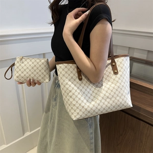 Elegant off-white monogram tote bag with brown leather straps and matching small pouch