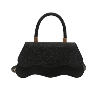 Chic black handbag with glitter wavy flap and gold hardware on white background