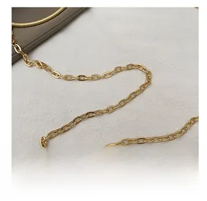 Close-up of a premium gold oval link metal chain strap on a textured white fabric