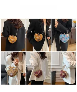 Detailed view of heart-shaped sequin evening bags with elegant metal handles and chain straps