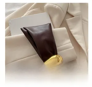 Detailed macro view of deep brown pleated leather texture with golden oval buckle