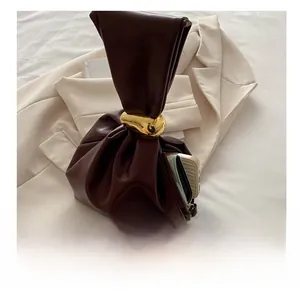 Detail of dark brown leather bucket bag showing spacious interior for phone and wallet