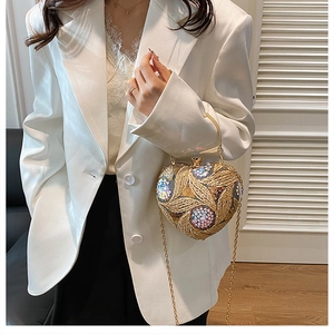 Detail of heart-shaped evening bag with gold embroidery, sequins and metal handle
