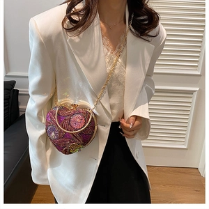Close-up of heart-shaped evening bag with purple floral embroidery and sequins
