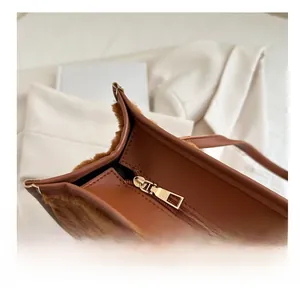 Detail of smooth gold zipper closure on brown plush and PU leather handbag