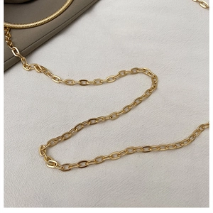 Detail of high-quality polished gold metal chain strap on a stylish handbag