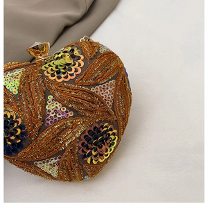 Macro detail of heart-shaped clutch with gold embroidery and colorful floral sequins