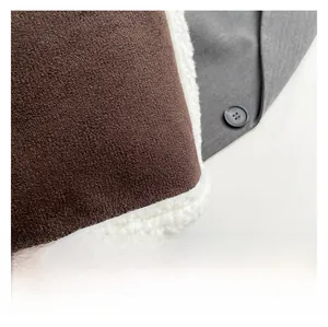 Gros plan d'une veste en daim marron avec doublure en peau de mouton blanche et bouton