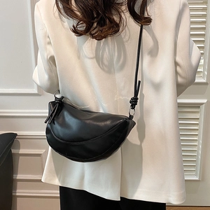 Minimalist black half-moon shoulder bag in soft leather with stylish knotted strap detail