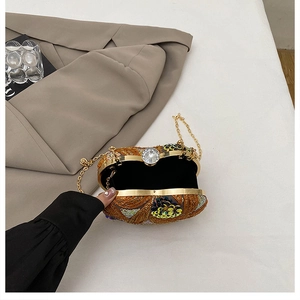 Detailed view of an open sequined evening clutch with gold metal frame and rhinestone clasp