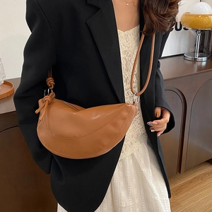 Chic brown crescent leather shoulder bag with knotted strap and silver metal rings