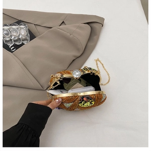 Detail of open sequined heart clutch showing interior lining and gold chain strap