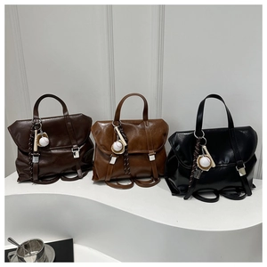 Detailed view of vintage tote backpacks in brown and black with baseball charms