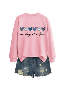 Dettaglio della felpa rosa con scritta e pantaloncini di jeans blu coordinati