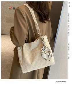 Close-up of cream canvas tote bag with waffle texture and decorative silk scarf detail