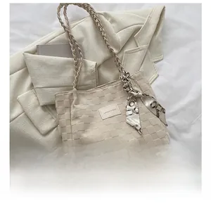 Detailed top view of large cream woven tote bag with silk scarf and phone for size