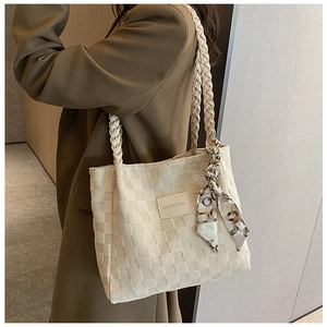 Detail of white woven tote bag with a patterned silk scarf and fashion leather label