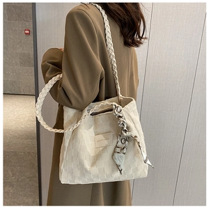 Detailed view of cream canvas tote bag with textured grid fabric and elegant silk scarf