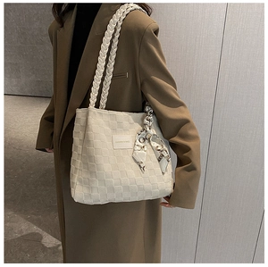 Detail of off-white woven tote bag with checkerboard pattern and decorative silk scarf