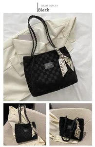 Detail of black woven tote bag with printed silk ribbon and fashion logo label