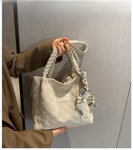 Detail of white woven checkered tote bag with braided handle and silk scarf decor