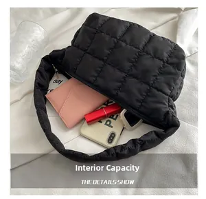 Internal view of black quilted shoulder bag showing phone and wallet storage