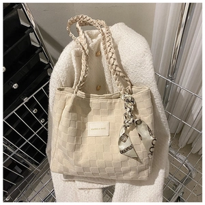 Detail of beige tote bag with woven texture, knotted rope handle and print silk scarf