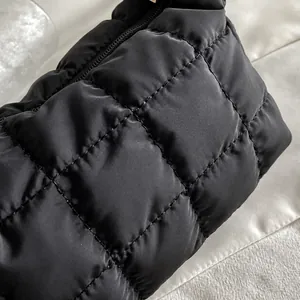Macro shot of black quilted bag fabric with square patterns and durable metal zipper