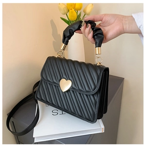 Detail der schwarzen Stepptasche mit Herzschloss und dekorativem Raffgriff-Design