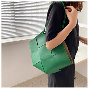 Detail of green large woven tote bag featuring modern Intrecciato square weave design