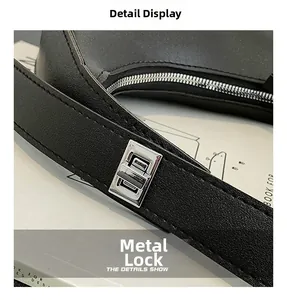 Close-up of black leather bag with silver metal hardware lock and fine stitching detail