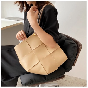 Detailed view of the beige woven leather tote bag texture and large capacity design