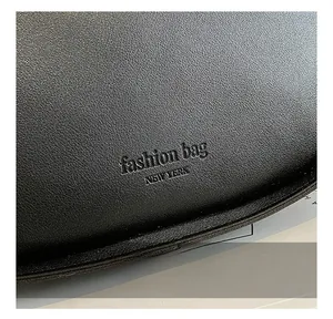 Macro shot of black lychee grain leather featuring debossed fashion bag New York logo
