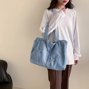 Fashionable light blue denim tote bag for women featuring large pockets and casual style