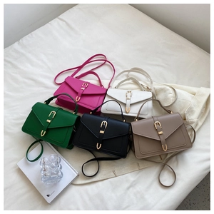 Nahaufnahme kleiner Leder-Quadrat-Taschen in fünf Farben mit Gold-Schnallen und Riemen