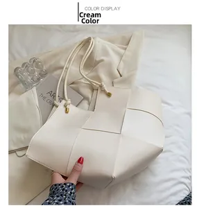 Detail view of beige woven tote bag with wide synthetic leather strips in minimalist style