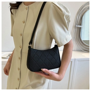 Schicke schwarze Stepptasche mit klassischem Rautenmuster, präsentiert von einem Modell