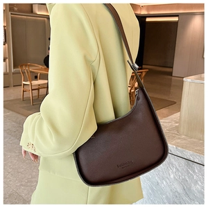 Detail of dark brown leather underarm bag featuring a delicate grain and side profile