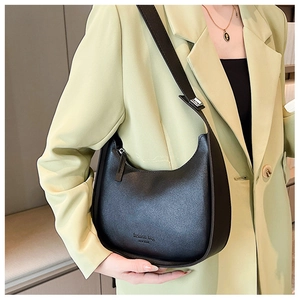 Detail of a black half-moon shoulder bag featuring stylish fashion bag New York lettering