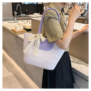 Detail of hand-woven purple and white tote bag featuring a decorative lace bow